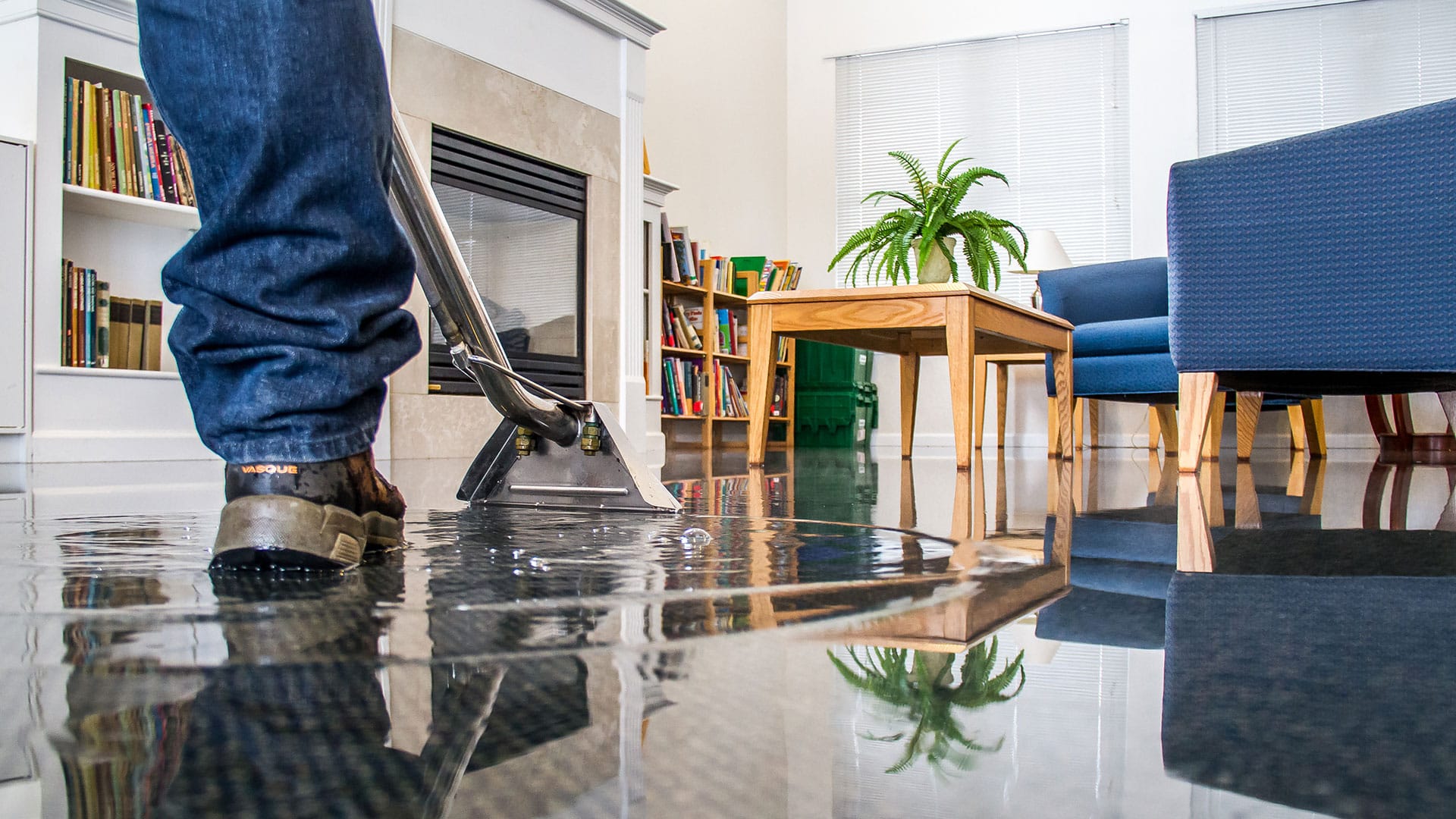 Flood repair experts extracting water from a flooded living room